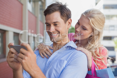 Stylish young couple looking at smartphone