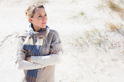 Attractive blonde standing on the beach in woolen scarf