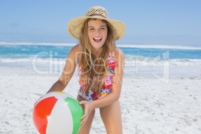 Fit laughing blonde in white bikini and straw hat holding beach