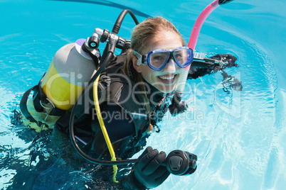 Smiling woman on scuba training in swimming pool