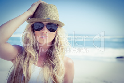 Stylish blonde looking at camera on the beach