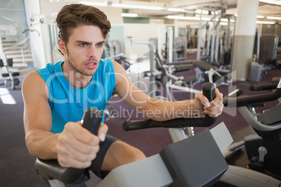 Focused fit man on the exercise bike