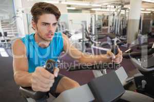 Focused fit man on the exercise bike