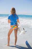 Fit surfer girl on the beach with her surfboard