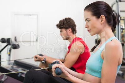 Focused brunette working out on the rowing machine