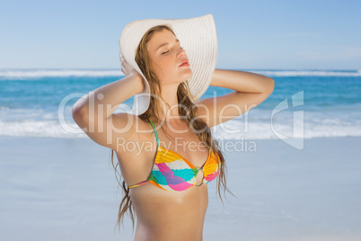 Beautiful girl in bikini and straw hat on the beach