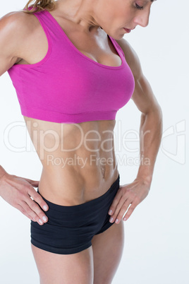 Female bodybuilder posing in pink sports bra