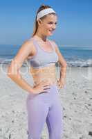 Sporty smiling blonde standing on the beach