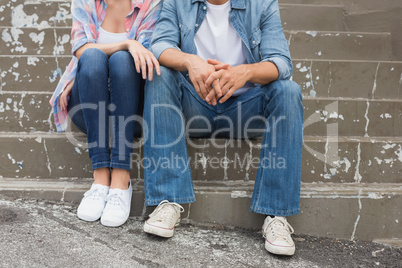 Hip young couple sitting on steps