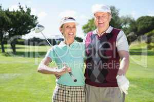 Golfing couple smiling at camera