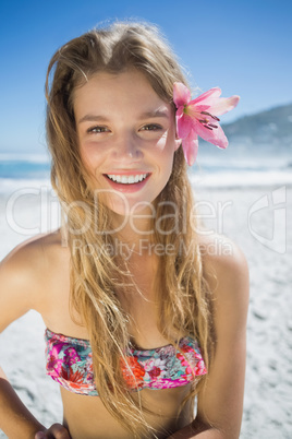 Beautiful smiling blonde with flower hair accessory on the beach