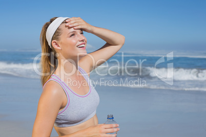 Sporty happy blonde standing on the beach