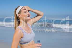 Sporty happy blonde standing on the beach