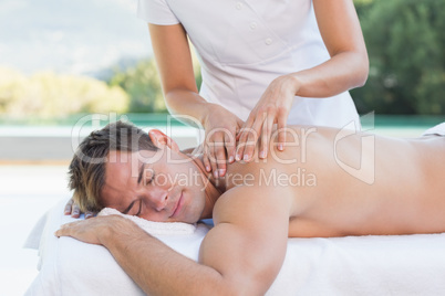 Handsome man getting a massage poolside