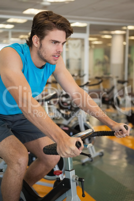 Focused fit man on the spin bike