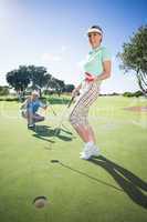 Golfing couple cheering on the putting green