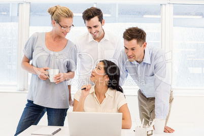 Casual business team having a meeting using laptop