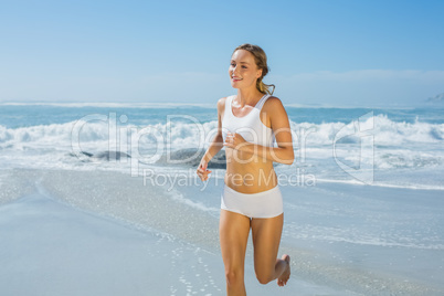 Gorgeous fit blonde jogging by the sea