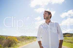 Handsome casual man standing on a road