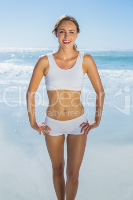 Gorgeous blonde standing by the sea smiling at camera