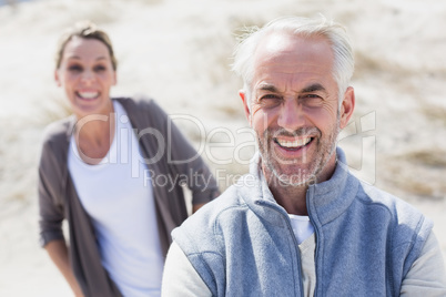 Couple smiling at camera on the beach