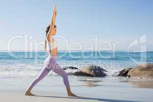 Sporty blonde stretching on the beach