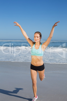 Fit woman stretching on the beach