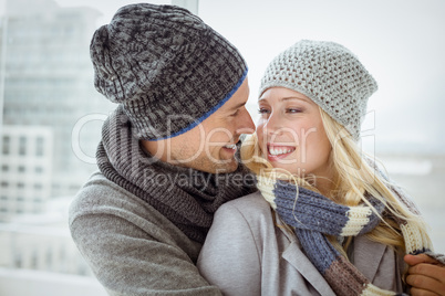 Cute couple in warm clothing smiling at each other