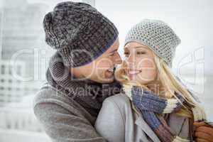 Cute couple in warm clothing smiling at each other