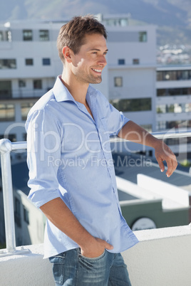 Handsome man looking over his balcony