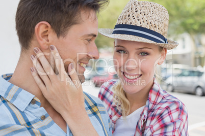 Young hip couple smiling with woman smiling at camera