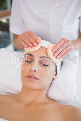 Peaceful brunette getting facial from beauty therapist