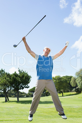 Excited golfer jumping up and smiling at camera