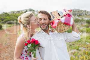 Cute couple going for a picnic with woman kissing boyfriends che