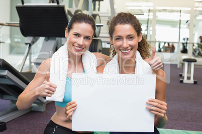 Fit friends showing white card to camera