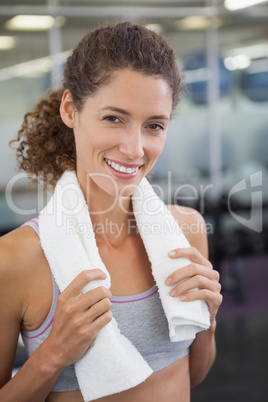 Fit woman smiling at camera with towel around shoulders