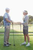 Golfing couple standing and talking