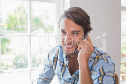 Smiling casual man talking on smartphone