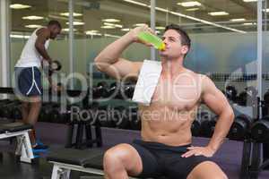 Shirtless bodybuilder drinking sports drink