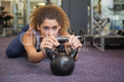 Fit woman lying with kettlebell