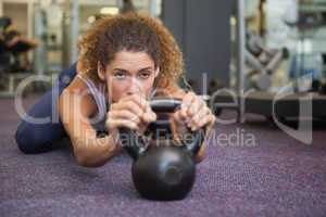 Fit woman lying with kettlebell