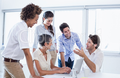 Casual business team having a meeting using laptop