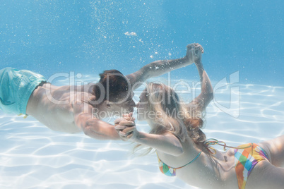 Cute couple kissing underwater in the swimming pool