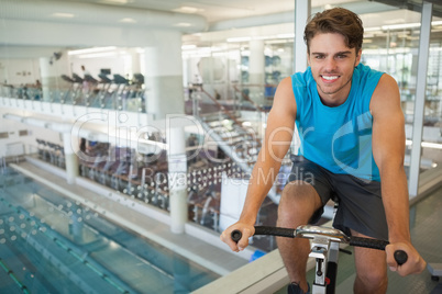 Smiling fit man on the spin bike