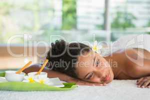 Gorgeous woman lying on massage table with salt treatment on bac