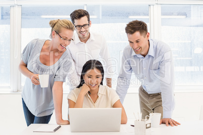 Casual business team having a meeting using laptop