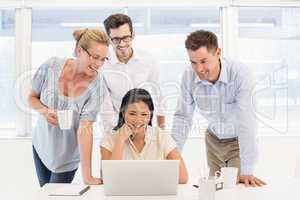 Casual business team having a meeting using laptop