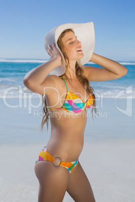 Beautiful girl in bikini and straw hat on the beach