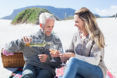 Couple enjoying white wine on picnic at the beach