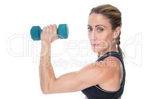 Female bodybuilder holding a blue dumbbell looking at camera